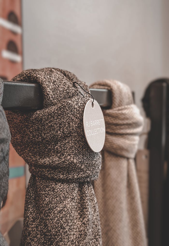 Fashion-forward wool scarves elegantly displayed in store, highlighting the RJ Barrett collection.